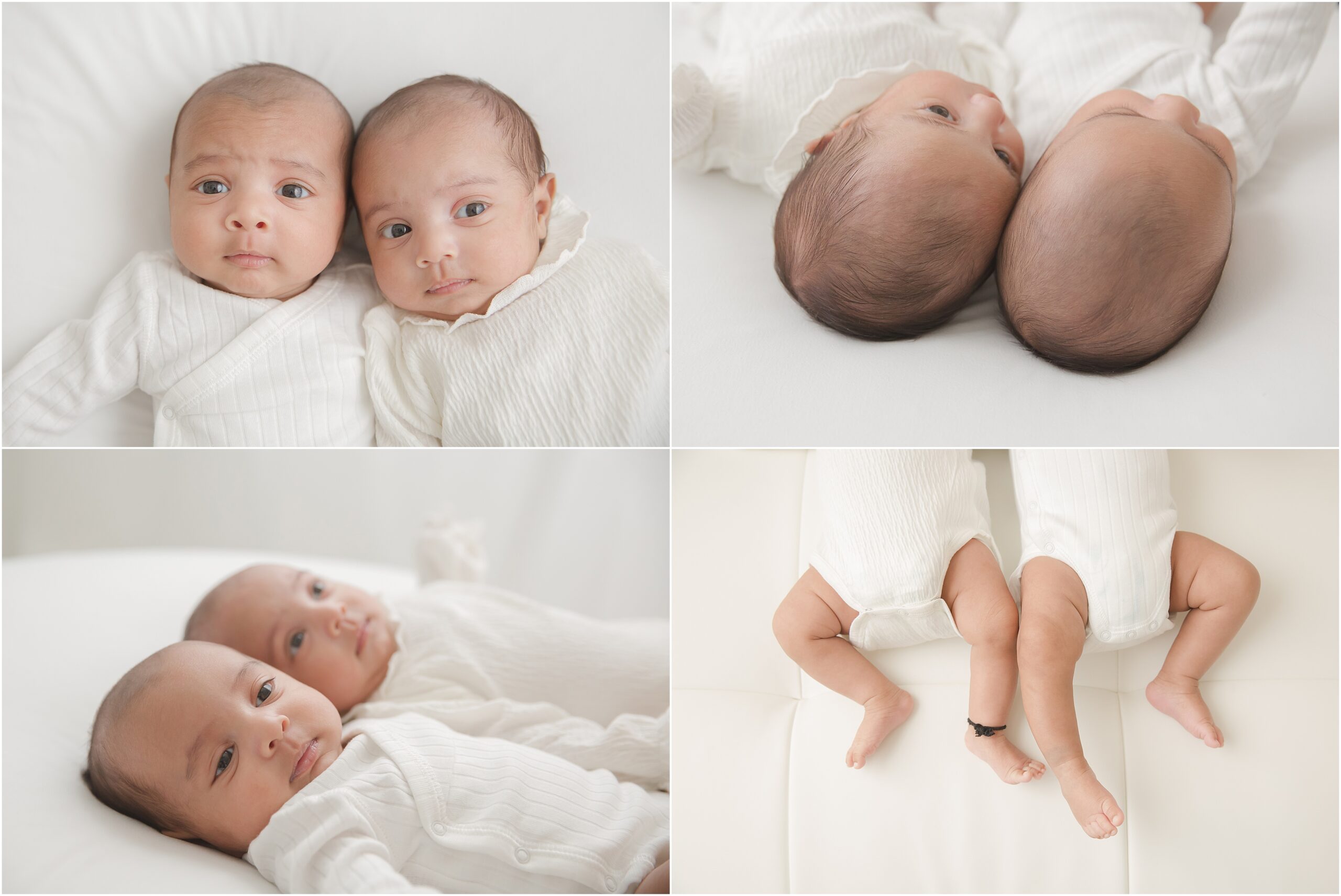 Newborn boy and girl twins wearing white outfits snuggle together on a white couch