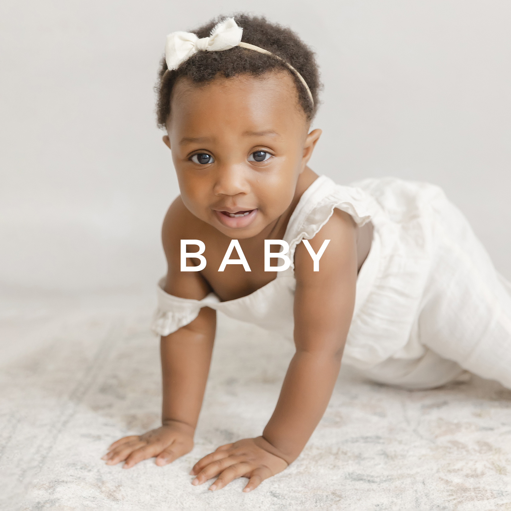 Baby girl in cream crawls toward the camera