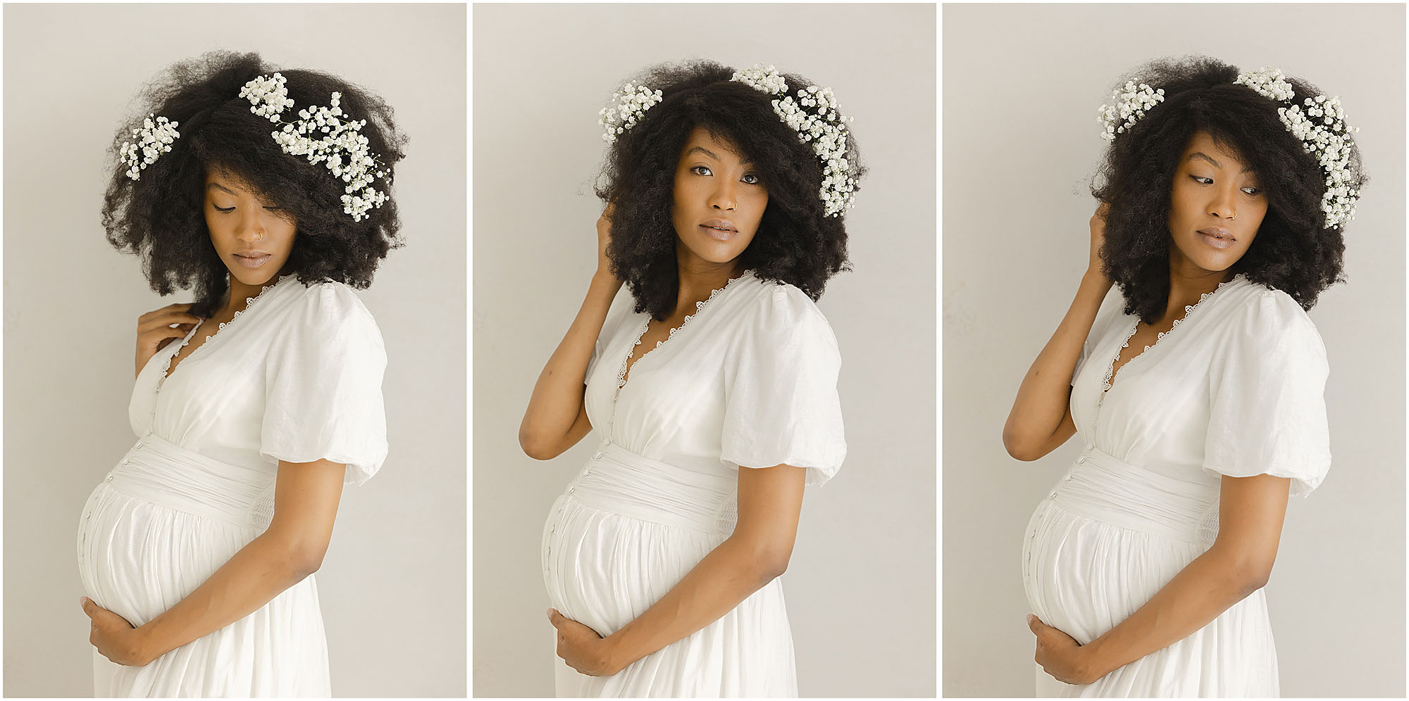 African American woman in a white dress with baby's breath in her hair poses for maternity photos in Wake Forest, NC