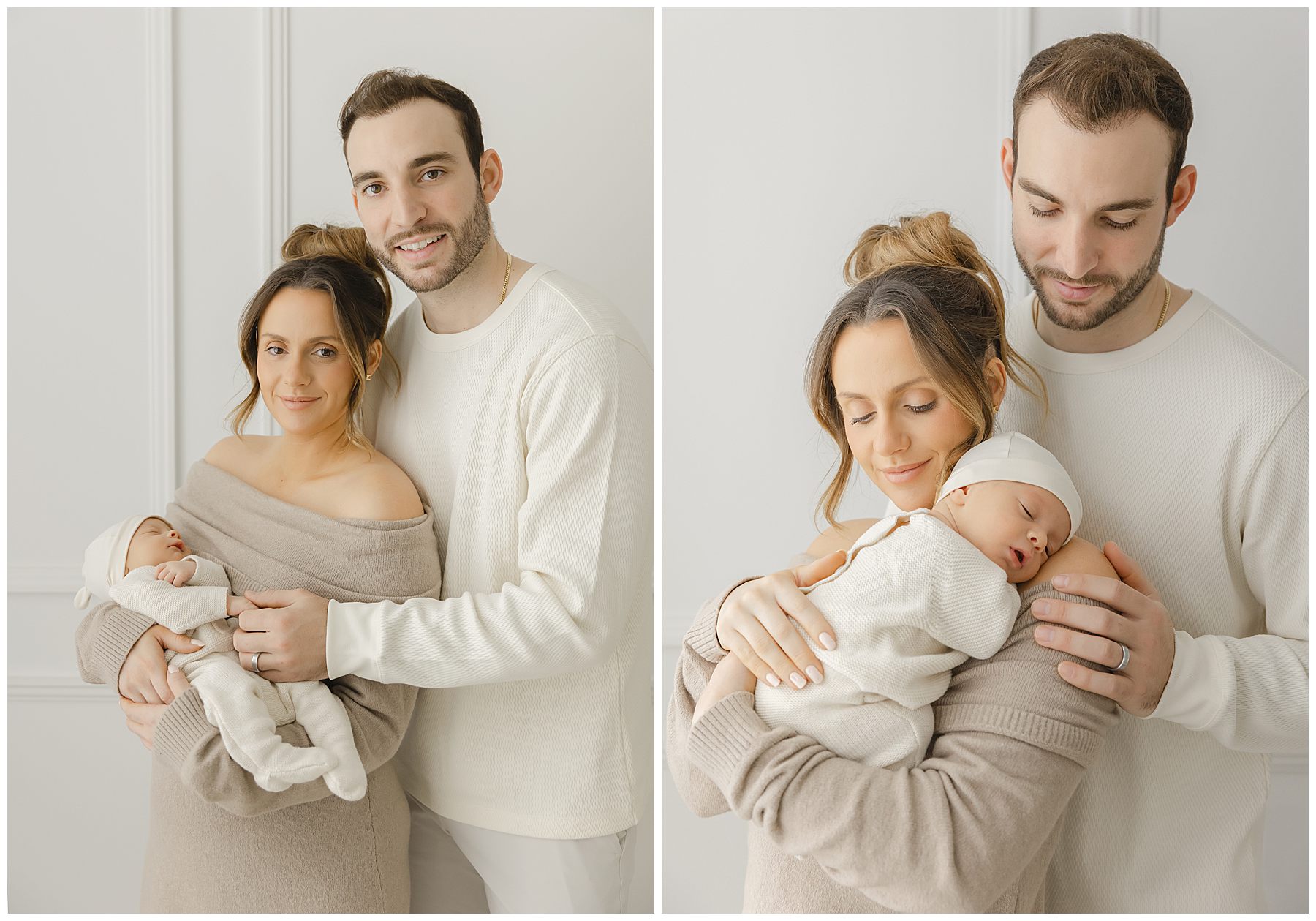 A couple wearing neutral outfits smiles while holding their newborn baby